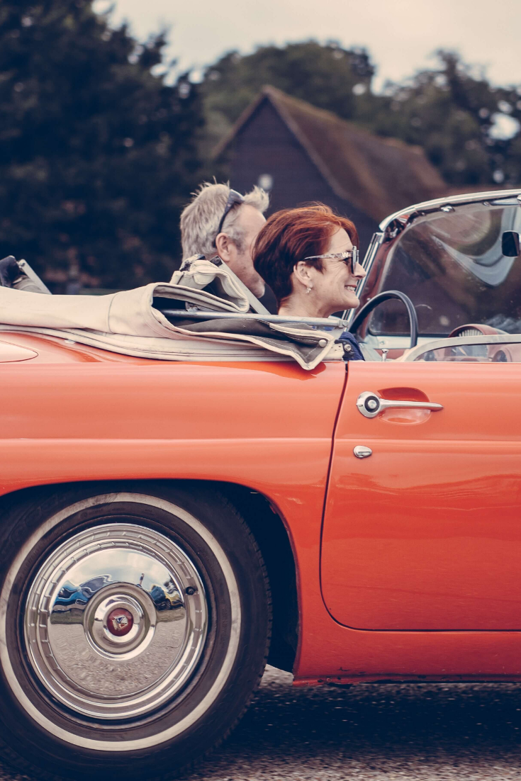 Couple in a Classic Red Convertible Two Seat Car