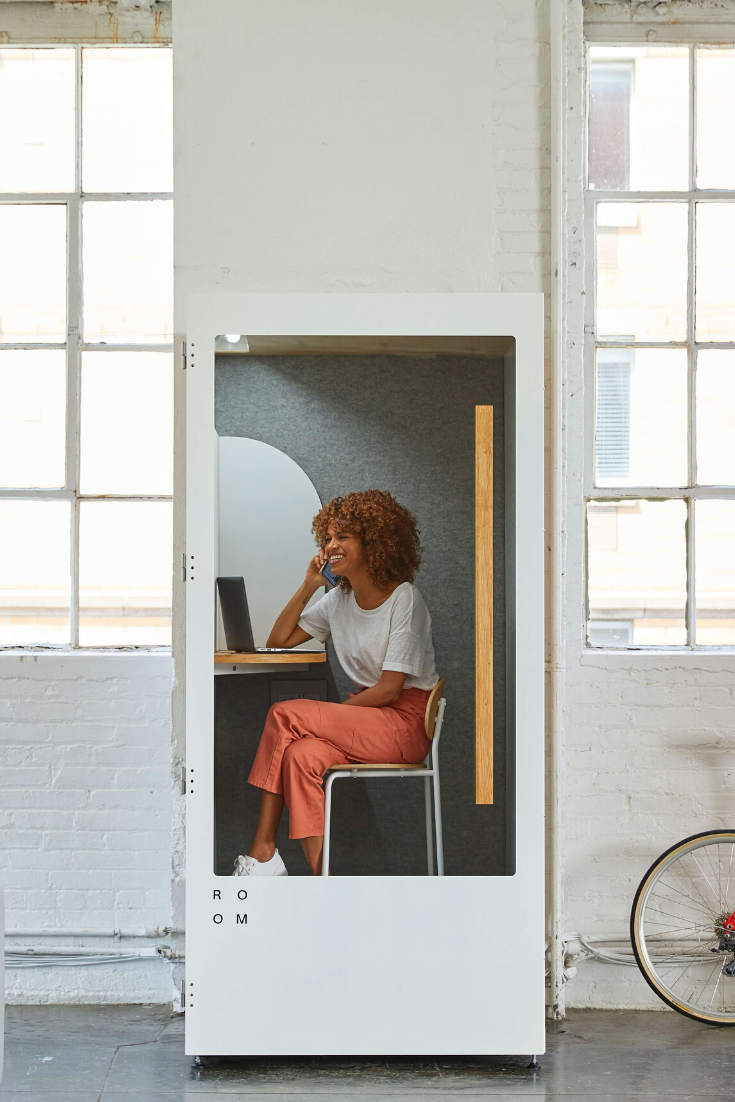 Woman in a White Phone Booth Talking on the Phone