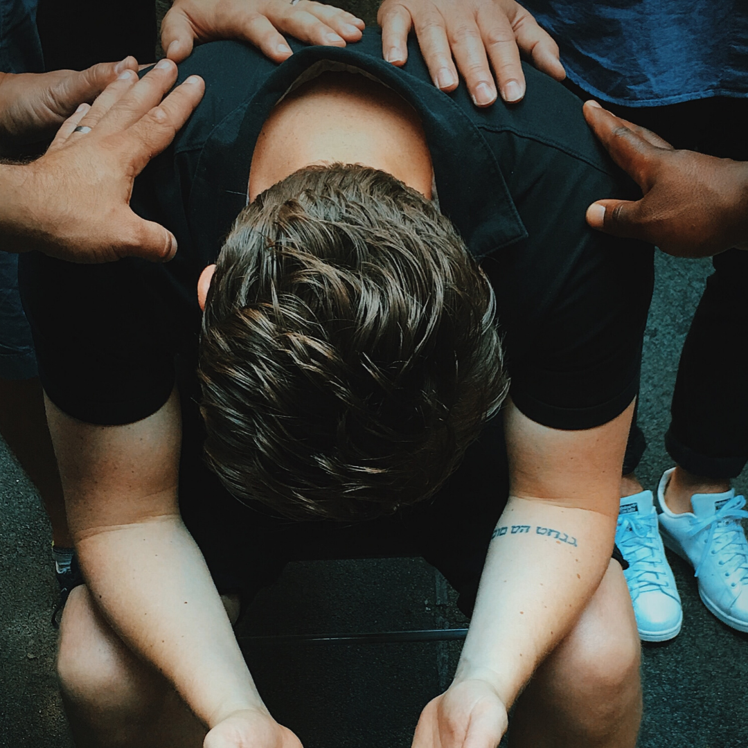 Hands on man with his hands raised praying