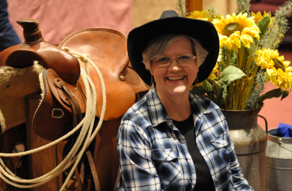 Woman in front of saddle.